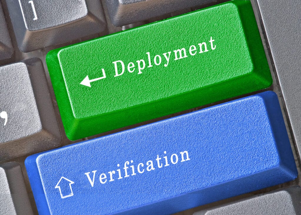 Grey computer keyboard with a green button that reads "Deployment" and a blue button that reads "Verification."