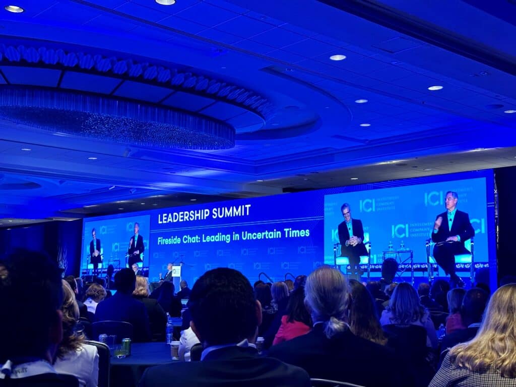 Image of two people sitting on a stage in conversation at the ICI Leadership Summit.