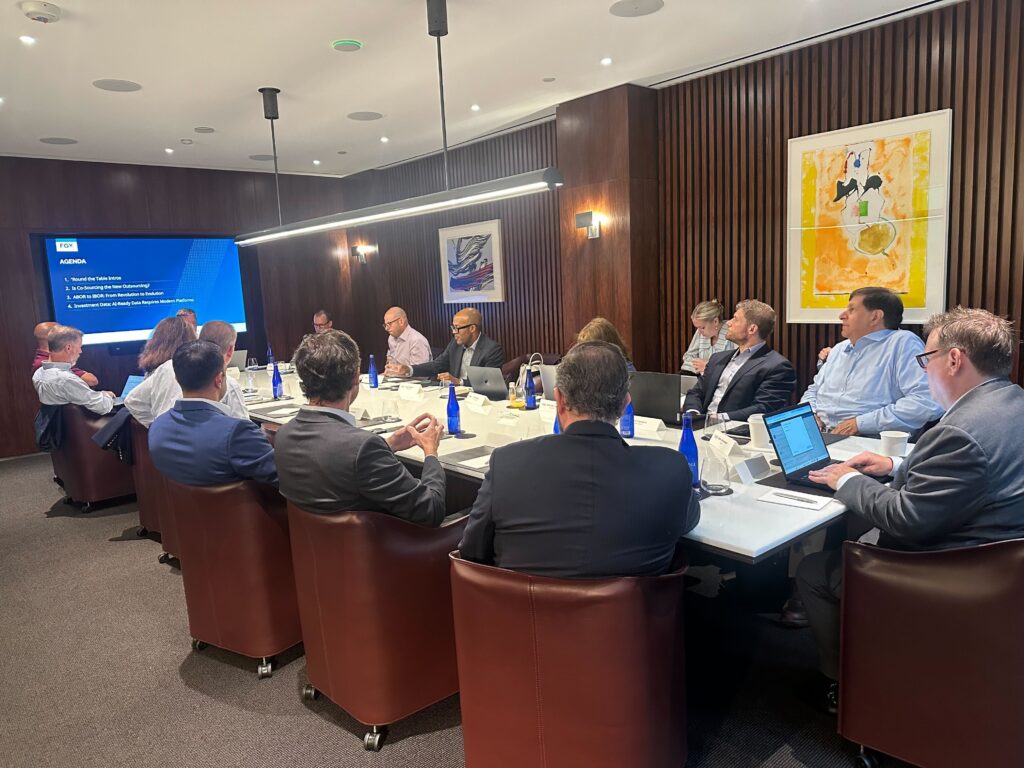An image of roundtable participants sitting around a table in conversation.